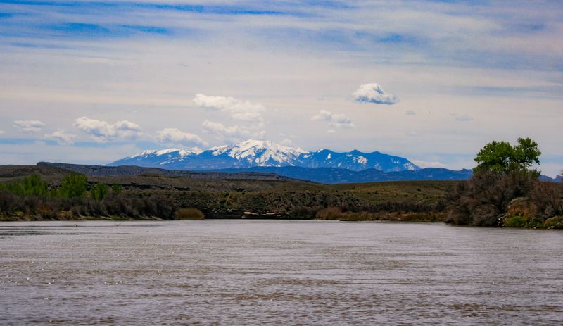 The wide, silt-brown Colorado running toward low desert benches