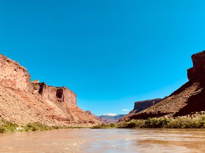Water-level view down the muddy Colorado River below Dewey Bridge
