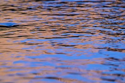 Abstract pattern of rippled river water at dusk reflecting bands of pink and blue sky in Westwater Canyon.