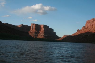 Broad rippled reach of the Green River in Labyrinth Canyon with sunlit buttes downstream and the banks falling into afternoon shadow.