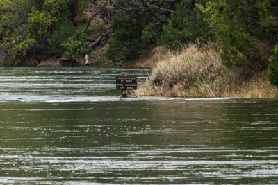 A lifejacket-required sign half-submerged in high water.