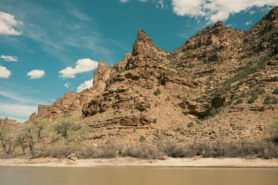 A layered red and tan sandstone buttress rising sharply from the river bank.