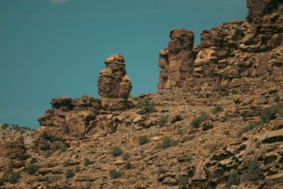 A balanced hoodoo silhouetted against an overcast sky on the canyon rim.