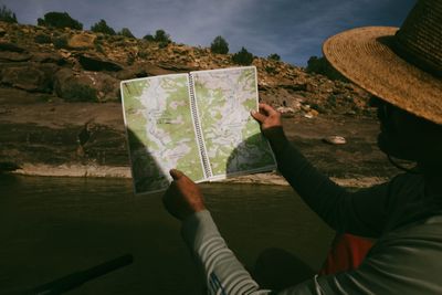 A topographic river map held up against the canyon, the river corridor visible on the page.