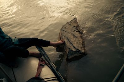 River runner pushing the raft off a shallow rock with bare feet at low water.