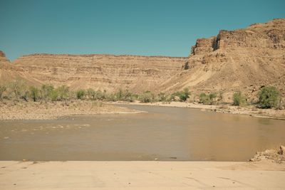 The river continues downstream below Swaseys between layered canyon walls and spring-green cottonwoods.